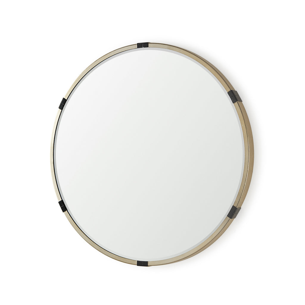 A round mirror with gold finish and black metal accent