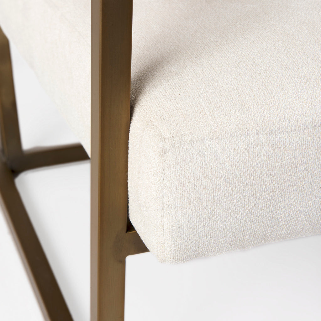 A metal and fabric accent chair oozing angular elegance.  Gold metal frame and cream fabric.