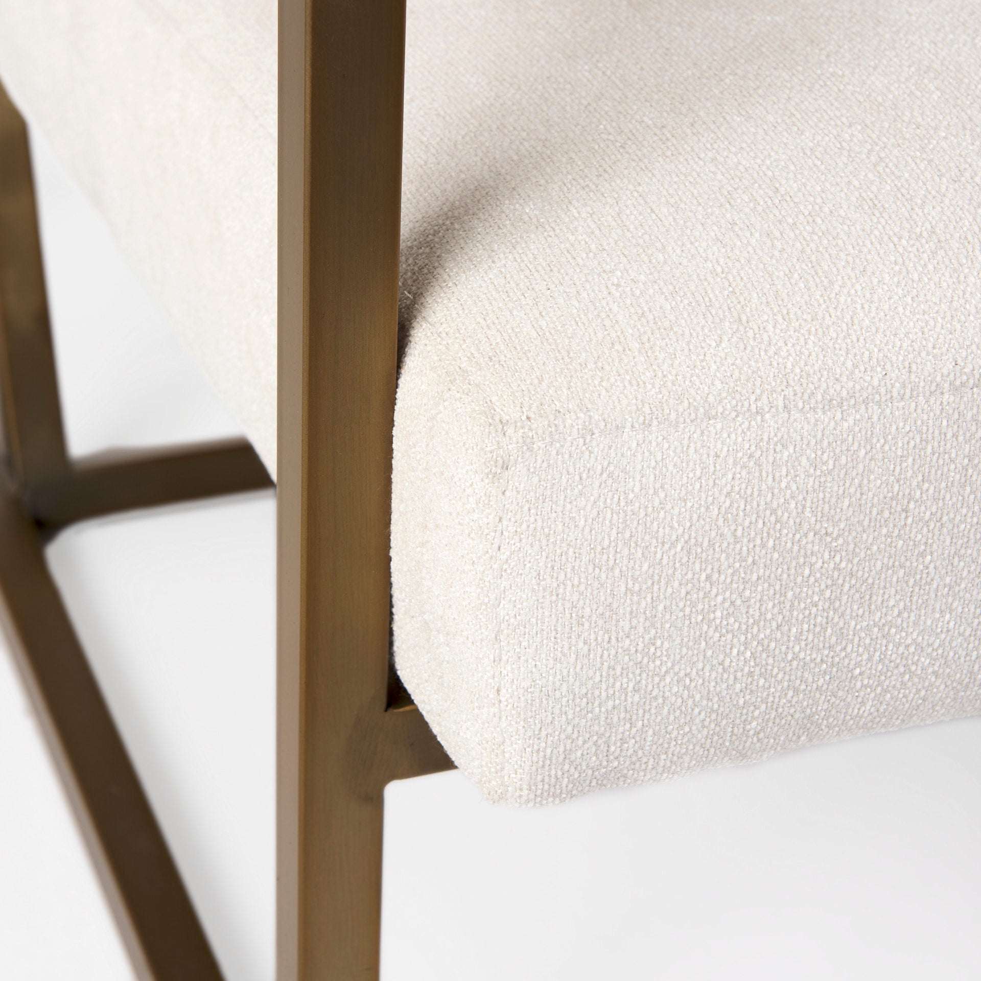A metal and fabric accent chair oozing angular elegance.  Gold metal frame and cream fabric.