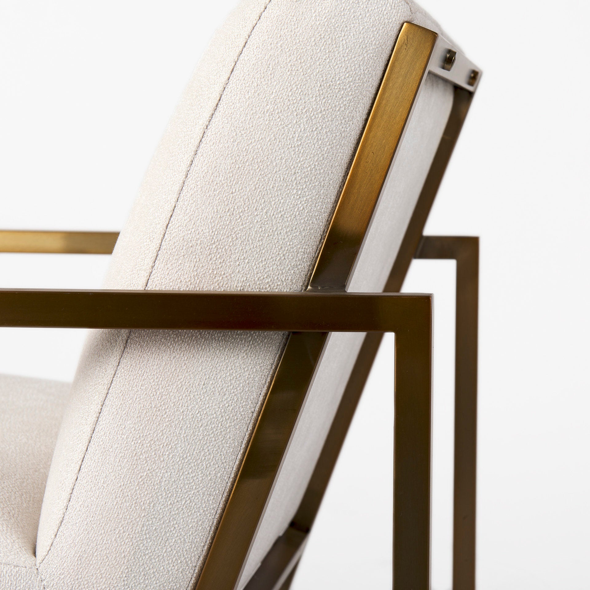 A metal and fabric accent chair oozing angular elegance.  Gold metal frame and cream fabric.
