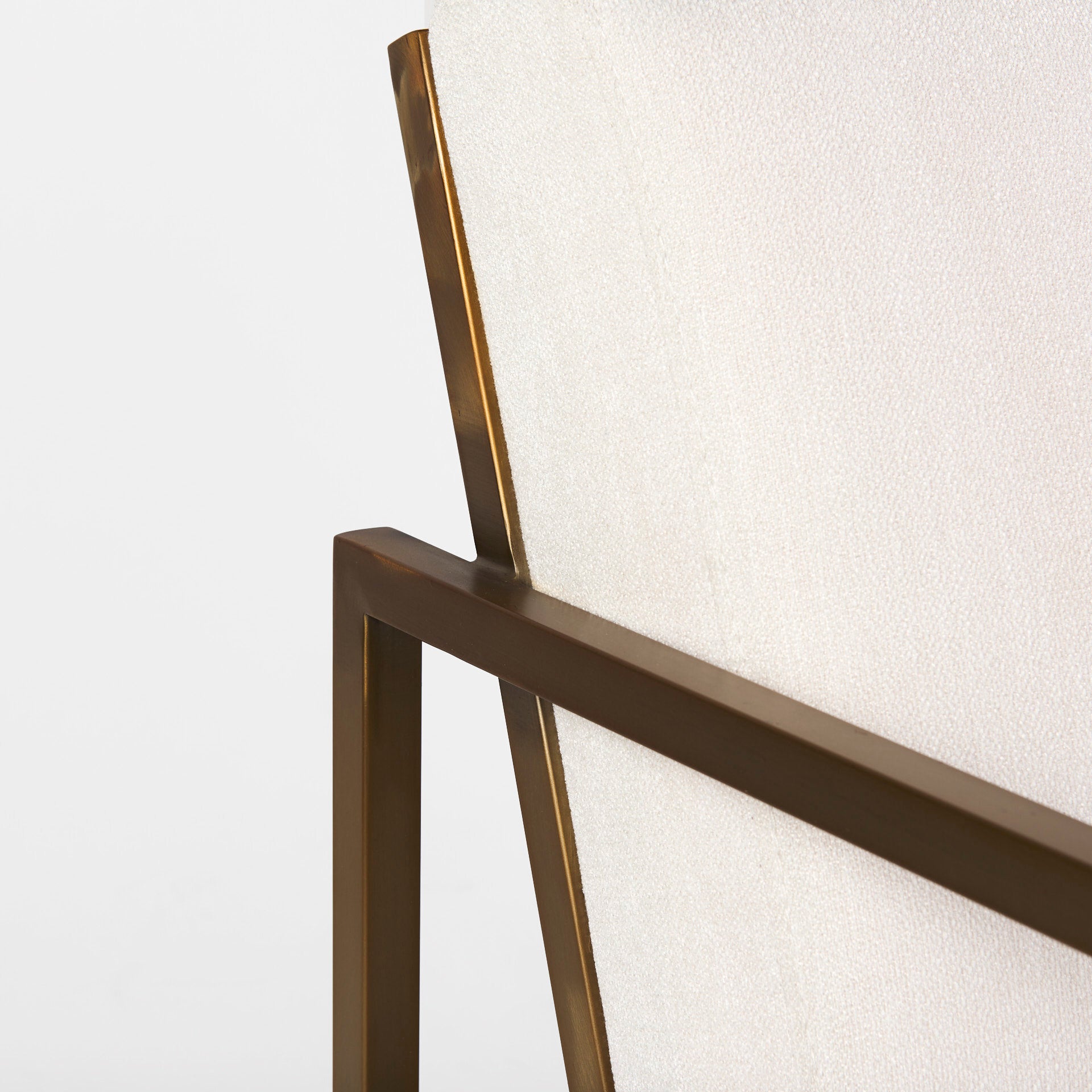 A metal and fabric accent chair oozing angular elegance.  Gold metal frame and cream fabric.